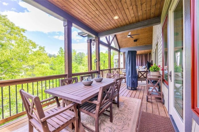 sunroom featuring beamed ceiling, ceiling fan, and wooden ceiling