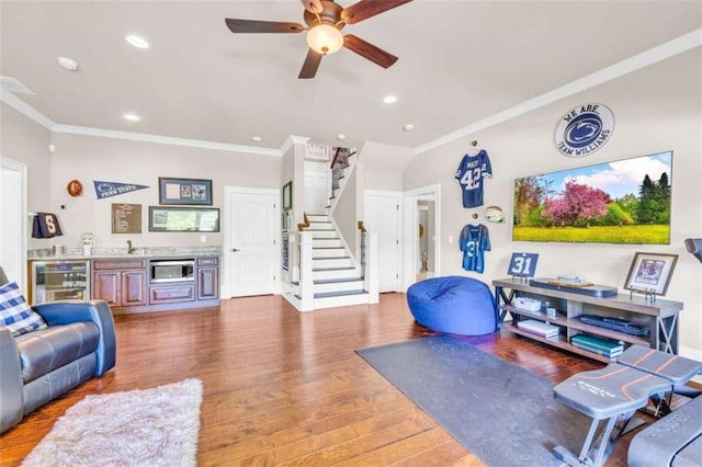 workout area with hardwood / wood-style floors, ceiling fan, ornamental molding, and beverage cooler