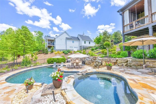 view of pool featuring a patio area and an in ground hot tub