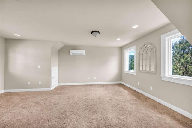 carpeted spare room with a healthy amount of sunlight and an AC wall unit