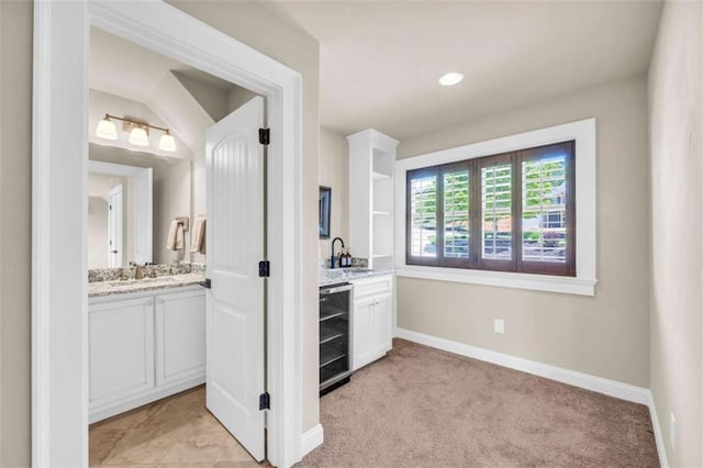 interior space featuring light carpet, sink, and beverage cooler