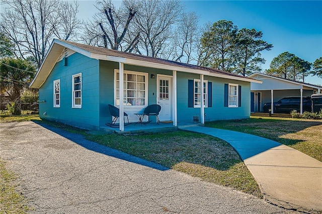 ranch-style home with a front lawn and covered porch