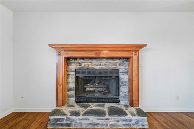 room details with a fireplace, baseboards, and wood finished floors