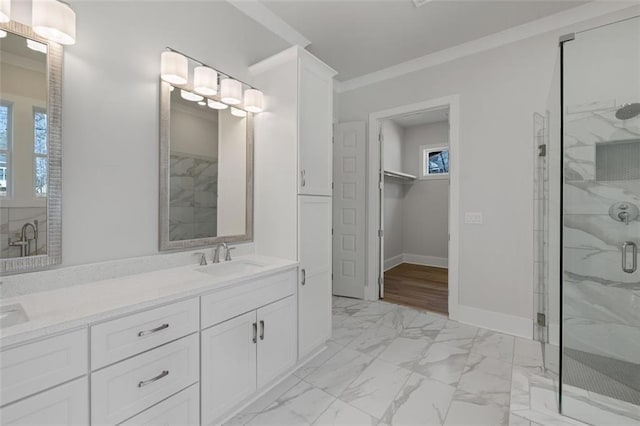 full bath featuring a sink, baseboards, marble finish floor, ornamental molding, and a stall shower