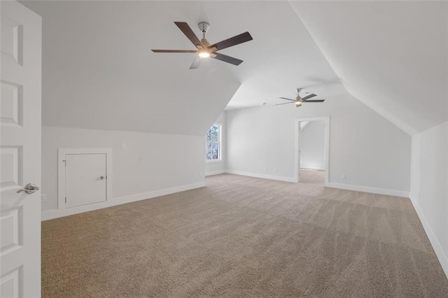 bonus room with lofted ceiling, baseboards, a ceiling fan, and light colored carpet