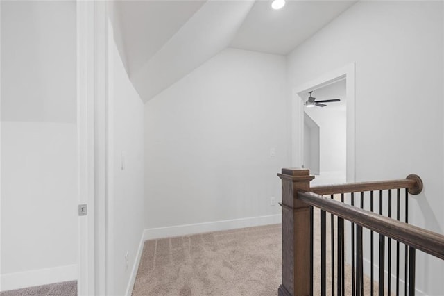 corridor featuring recessed lighting, carpet flooring, vaulted ceiling, an upstairs landing, and baseboards