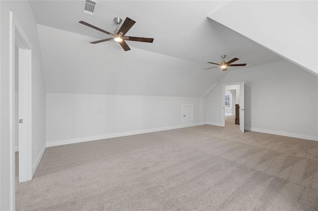 additional living space with lofted ceiling, ceiling fan, visible vents, and light colored carpet