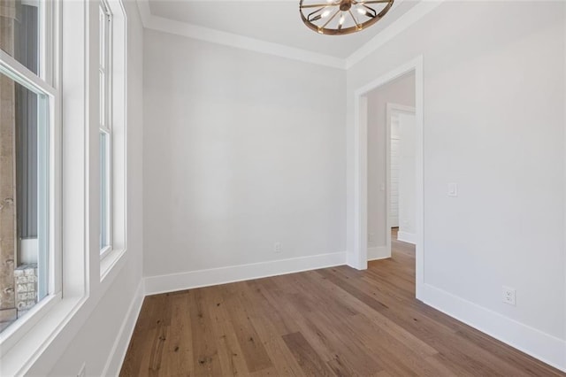 unfurnished room featuring baseboards, ornamental molding, and wood finished floors