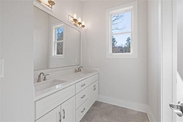 full bathroom featuring double vanity, a sink, and a healthy amount of sunlight