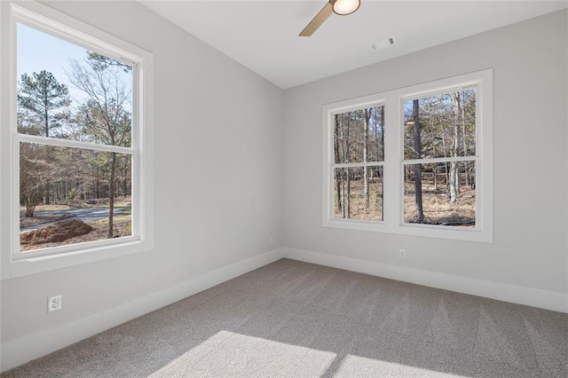 spare room with ceiling fan, carpet flooring, visible vents, and baseboards