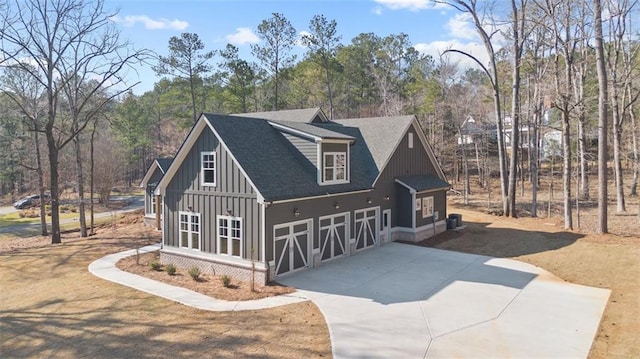 view of front of property featuring concrete driveway, a shingled roof, and board and batten siding