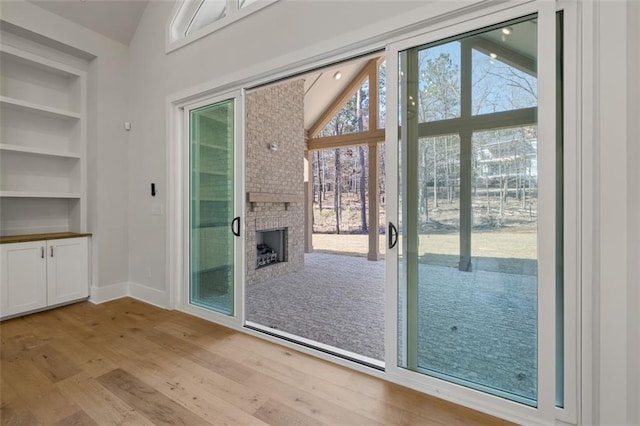 entryway with baseboards, light wood-style floors, a healthy amount of sunlight, and built in features