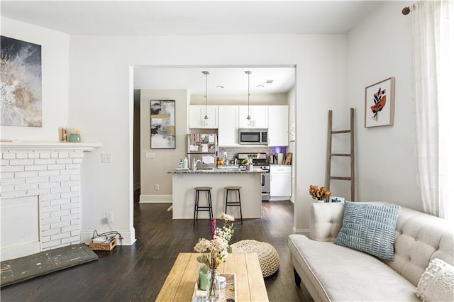 820 Elbert St SW, Atlanta, GA 30310 - living room featuring dark wood-type flooring, a fireplace, and baseboards