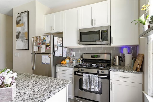 820 Elbert St SW, Atlanta, GA 30310 - kitchen with appliances with stainless steel finishes, white cabinets, decorative backsplash, and light stone counters