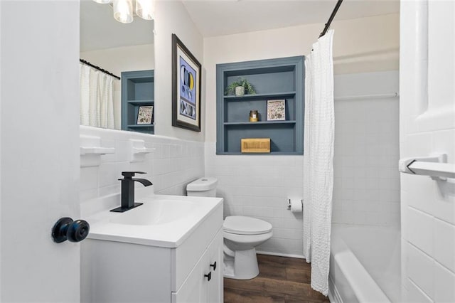 full bathroom with wood-type flooring, tile walls, vanity, toilet, and shower / bath combo