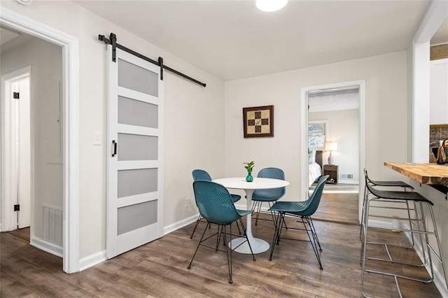 dining room with wood-type flooring and a barn door