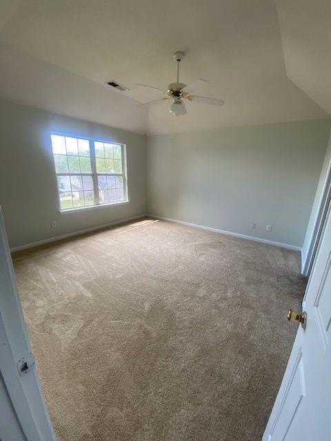 unfurnished room featuring lofted ceiling, carpet flooring, and ceiling fan