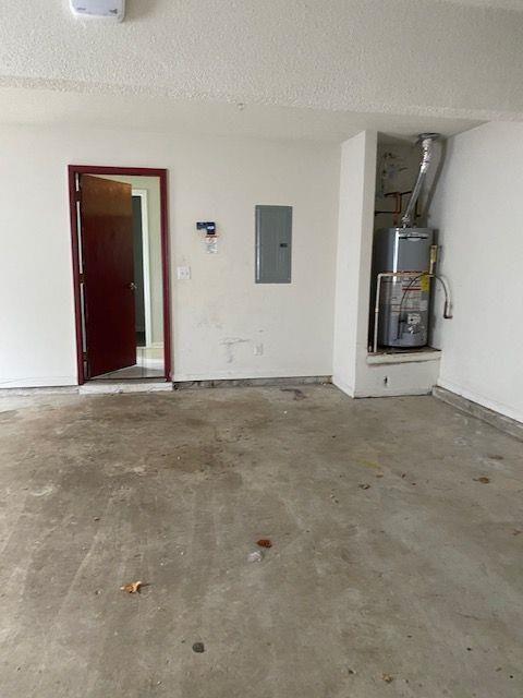 garage with electric panel and water heater