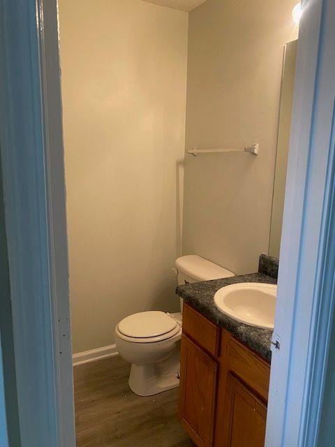 bathroom with vanity, toilet, hardwood / wood-style floors, and a textured ceiling