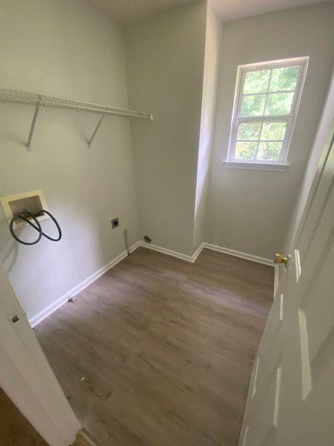 washroom with hookup for an electric dryer, dark hardwood / wood-style flooring, and hookup for a washing machine