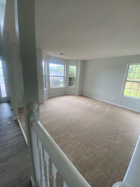 unfurnished room featuring dark carpet