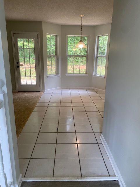 interior space featuring light tile patterned floors and a textured ceiling