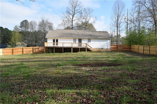 rear view of house featuring a wooden deck and a yard