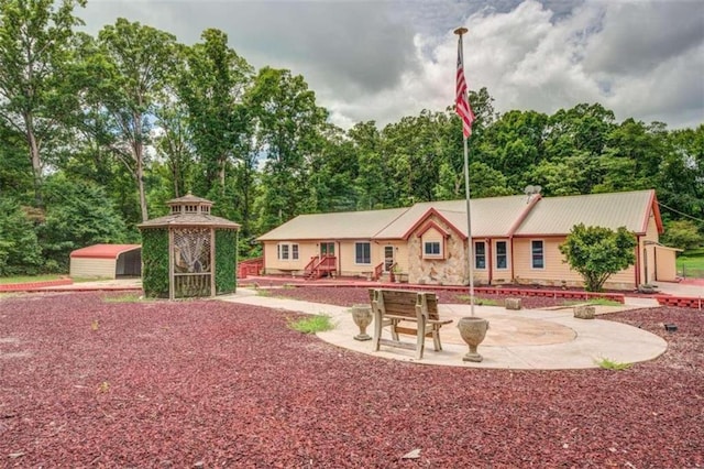 view of front of property featuring an outbuilding and a patio