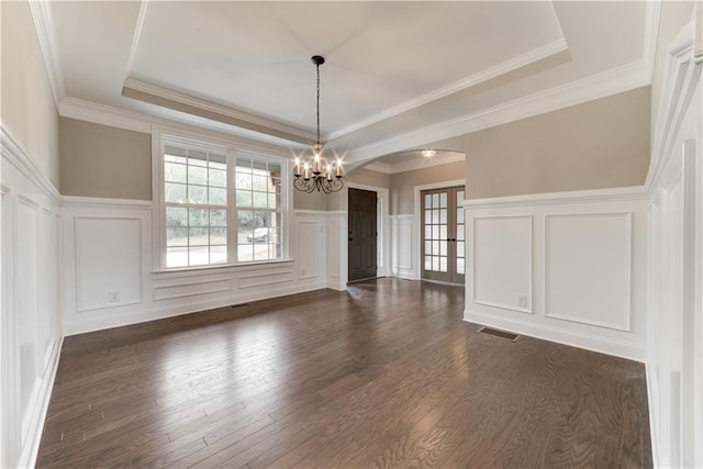 unfurnished dining area with a chandelier, dark hardwood / wood-style floors, crown molding, and a tray ceiling