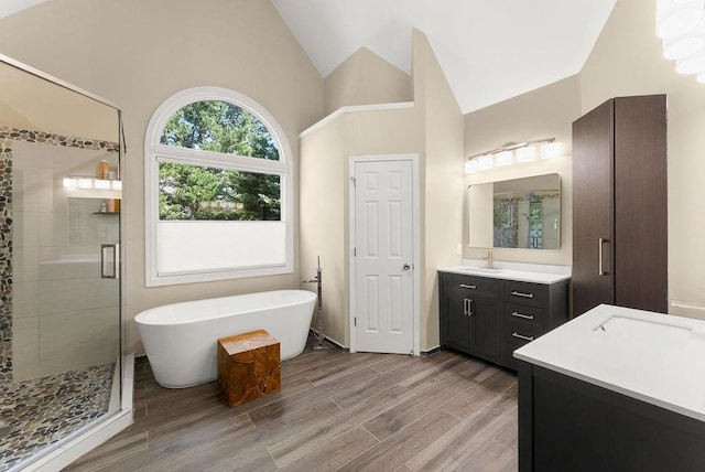 12350 Broadleaf Ln, Johns Creek, GA 30005 - bathroom featuring a stall shower, vanity, a freestanding tub, wood finished floors, and high vaulted ceiling