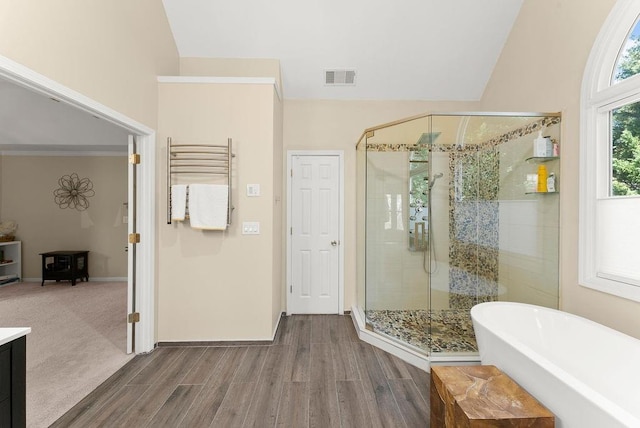 12350 Broadleaf Ln, Johns Creek, GA 30005 - bathroom with a freestanding tub, wood finished floors, a shower stall, baseboards, and lofted ceiling