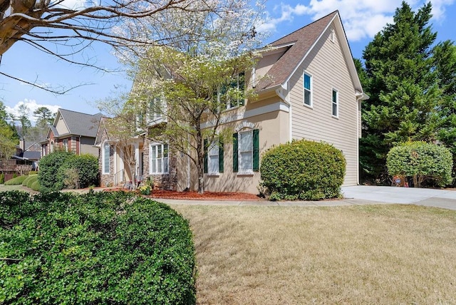 12350 Broadleaf Ln, Johns Creek, GA 30005 - obstructed view of property with a front lawn, roof with shingles, and stucco siding