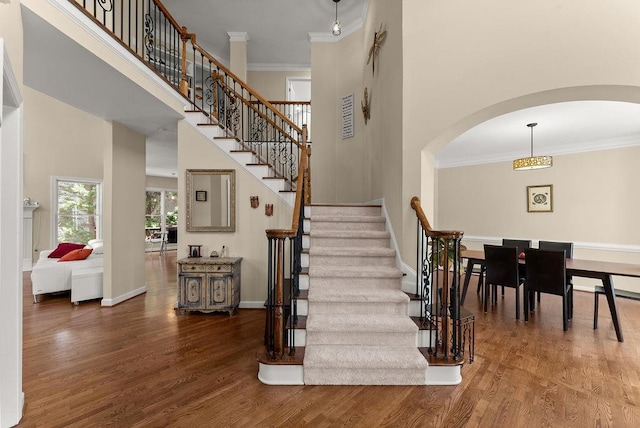 12350 Broadleaf Ln, Johns Creek, GA 30005 - stairway featuring arched walkways, wood finished floors, ornamental molding, a towering ceiling, and baseboards