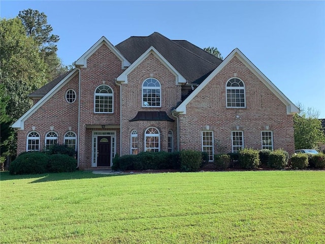 view of front of home featuring a front yard and brick siding