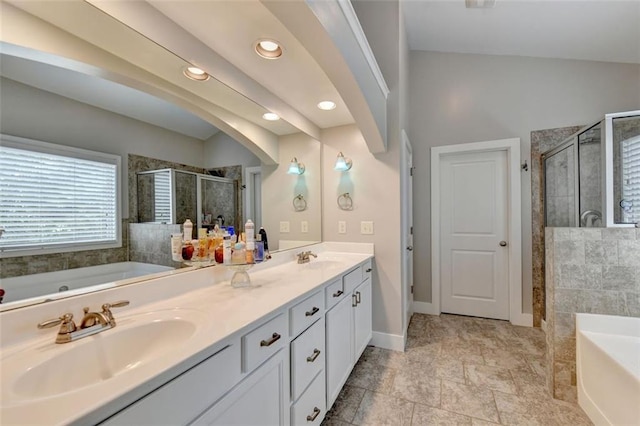 bathroom featuring independent shower and bath, vanity, and vaulted ceiling