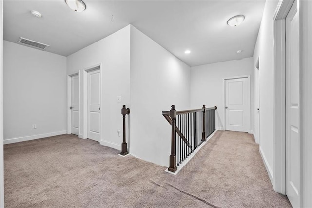 hall featuring light colored carpet