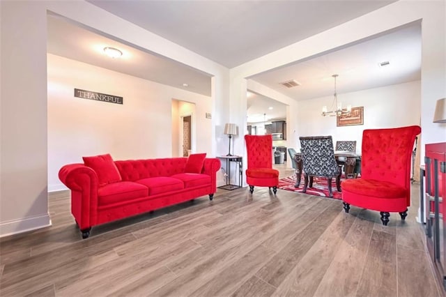 living room featuring a notable chandelier and wood-type flooring