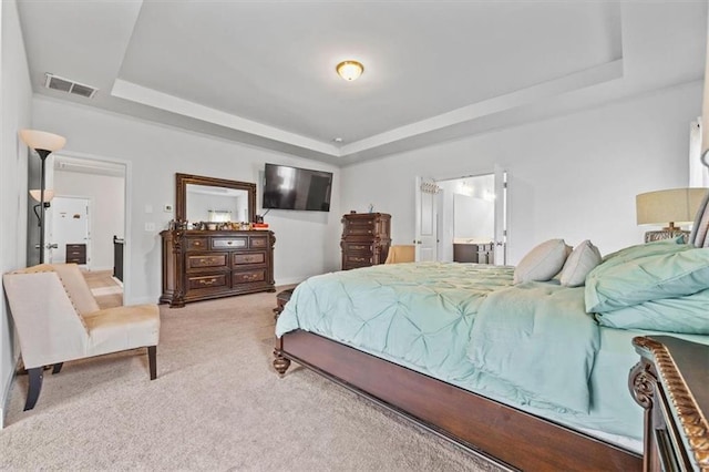 bedroom with light carpet and a tray ceiling