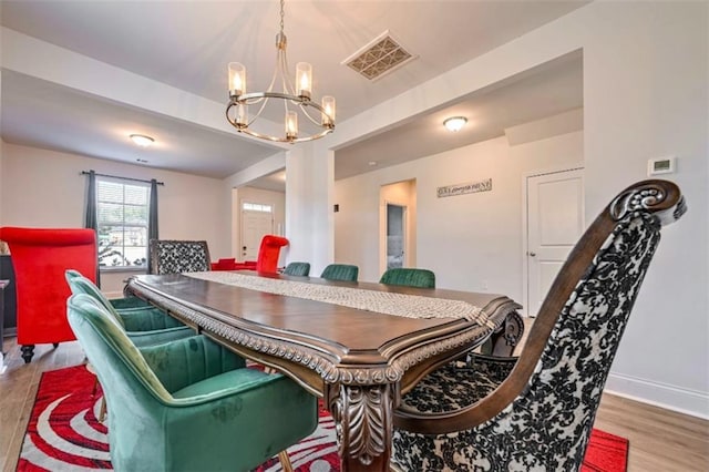 dining space featuring hardwood / wood-style flooring and a chandelier