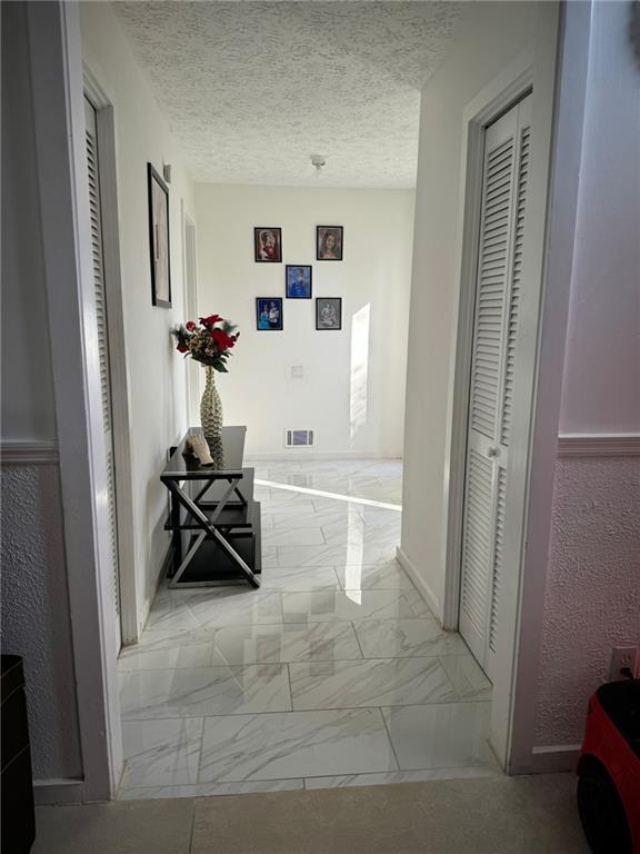 corridor with a textured ceiling