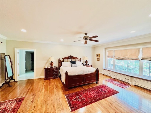 bedroom featuring light wood-type flooring, crown molding, and ceiling fan