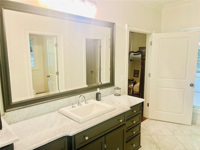 bathroom with vanity, crown molding, and toilet