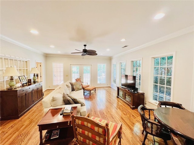 living room featuring ceiling fan, light hardwood / wood-style flooring, and crown molding