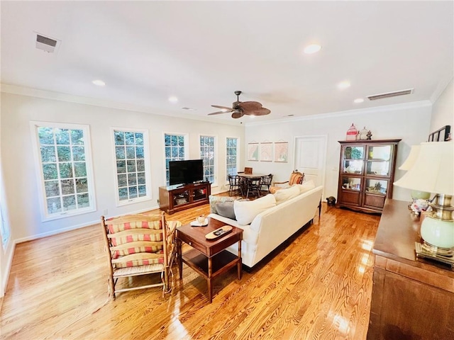 living room with ornamental molding, light hardwood / wood-style floors, and ceiling fan