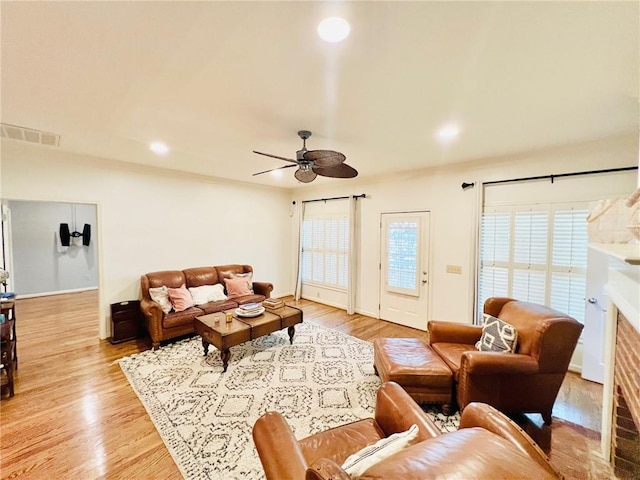 living room featuring ceiling fan, light hardwood / wood-style flooring, and plenty of natural light