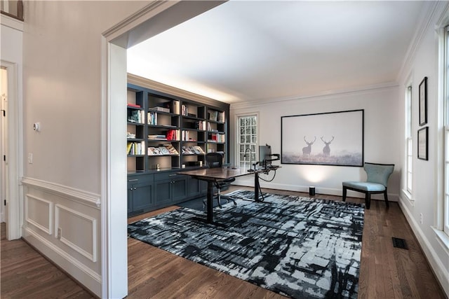 office space featuring dark wood-type flooring, crown molding, and built in features