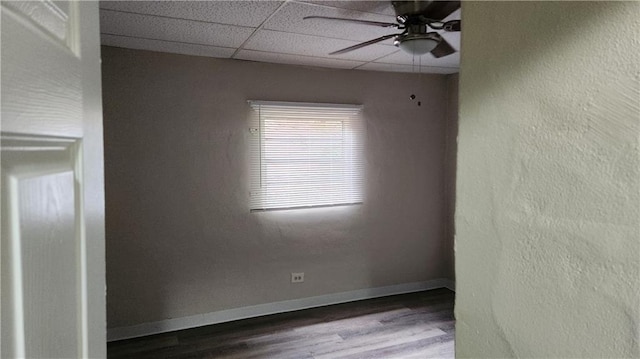 spare room featuring ceiling fan, a paneled ceiling, and wood-type flooring