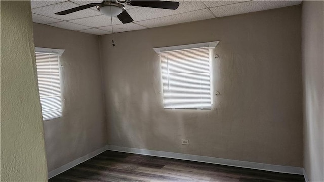 unfurnished room with dark hardwood / wood-style flooring, a paneled ceiling, and ceiling fan