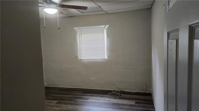 spare room featuring ceiling fan, a paneled ceiling, and dark wood-type flooring