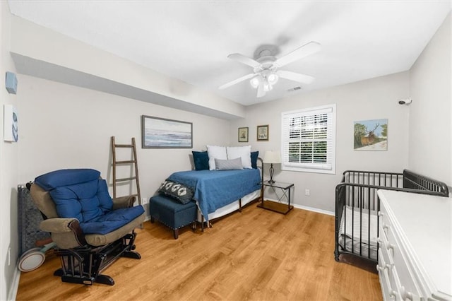 bedroom with light wood-style floors, baseboards, visible vents, and ceiling fan